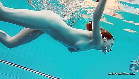 Russian redhead babe floats in the pool in black top